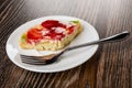 Piece of pie with slices of strawberry and kiwi, fork in plate on table Royalty Free Stock Photo