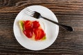 Piece of pie with strawberry and kiwi, fork in plate on wooden table. Top view Royalty Free Stock Photo