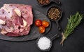 A piece of pork ham on a black board and spices olive oil, salt, rosemary branch and pepper Royalty Free Stock Photo