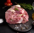 A piece of pork ham on a black board and spices olive oil, salt, rosemary branch and pepper Royalty Free Stock Photo