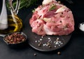A piece of pork ham on a black board and spices olive oil, salt, rosemary branch and pepper Royalty Free Stock Photo