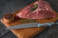 A piece of pork meat on a cutting Board with a knife and seasonings. Royalty Free Stock Photo