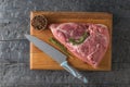 A piece of pork meat on a cutting Board with a knife and seasonings. The view from the top. Royalty Free Stock Photo