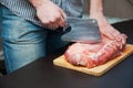 Piece of pork neck cutout on woodwn table. Man cutting meat Royalty Free Stock Photo