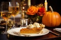 Piece of pumpkin pie revealing a rich golden spiced filling is elegantly served on a rustic wooden table with wine Royalty Free Stock Photo