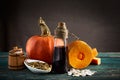 Piece of pumpkin, pumpkin seeds in sackcloth bag and wooden barrel, hemp seed and oil bottle. Close up.