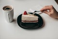 Piece of raspberry cheesecake dessert with coffee in a white cup on  table in a cafe Royalty Free Stock Photo