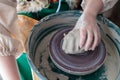 A piece of raw clay in the hands of a potter on a circle