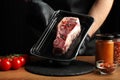 A piece of raw fresh meat vacuum-packed in the hands of a cook on a black background Royalty Free Stock Photo