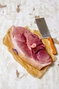 A piece of raw meat with a butcher knife on the paper. Royalty Free Stock Photo