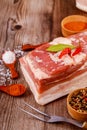 Piece of raw pork belly with garlic on wooden background Royalty Free Stock Photo