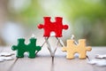 Piece of Red green and gold jigsaw puzzle On the old wood And green background. teamwork concept. symbol of association and Royalty Free Stock Photo