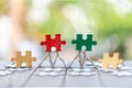 Piece of Red green and gold jigsaw puzzle On the old wood And green background. teamwork concept. symbol of association and Royalty Free Stock Photo