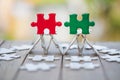 Piece of Red and green jigsaw puzzle On the old wood And green background. teamwork concept. symbol of association and