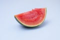 Piece of red watermelon without seeds resting on its green rind