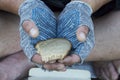 A piece of rye bread in the hands of a homeless man in gloves. Poverty, unemployment, hunger