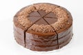 Sacher chocolate cake, cocoa biscuit with walnut filling and dark chocolate icing served on a plate.