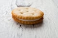 Sandwich biscuit with white cream filling on white wood background