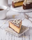 Piece Slice of ÃÂ¡heesecake with Chocolate, Caramel, Peanut Paste, Nougat Layered Cake on white table background Royalty Free Stock Photo