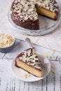 Piece Slice of ÃÂ¡heesecake with Chocolate, Caramel, Peanut Paste, Nougat Layered Cake on white table background Royalty Free Stock Photo