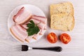 Piece, slices of brisket, parsley in plate, bread, tomatoes, fork on table. Top view