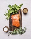 Piece of smoked salmon on a cutting board with herbs spices on wooden rustic background top view Royalty Free Stock Photo