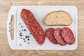 Piece of smoked sausage and slices on cutting board Royalty Free Stock Photo