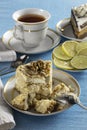 A piece of sponge cake on a white plate with a Cup of tea Royalty Free Stock Photo