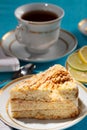 A piece of sponge cake on a white plate with a Cup of tea Royalty Free Stock Photo