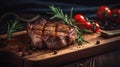 a piece of steak on a cutting board with a sprig of rosemary on top of it and tomatoes on the side of the cutting board Royalty Free Stock Photo