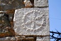 Piece of stone with sculptured symbol, detail from the exterior wall of an old house at Messiniaki Mani region in Peloponnese,