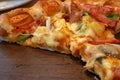 Piece of super deluxe pizza on wooden tray, Traditional Italian fast food Royalty Free Stock Photo