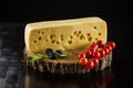 Piece of Swiss cheese, cherry tomatoes and olives on wooden boar