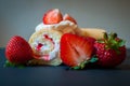 A piece of swiss roll filled with cream and strawberry jam. Fresh strawberries on side. Royalty Free Stock Photo