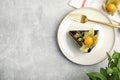 Piece of tasty cake decorated with physalis fruit on light grey table, flat lay. Space for text Royalty Free Stock Photo