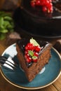 Piece of tasty homemade chocolate cake with berries and mint on wooden table, closeup. Space for text Royalty Free Stock Photo