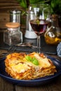 Piece of tasty hot lasagna with red wine.