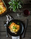 Piece of tasty hot lasagna with red wine. Small depth of field. Traditional italian lasagna. Portion. Italian food. Food on black Royalty Free Stock Photo