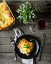 Piece of tasty hot lasagna with red wine. Small depth of field. Traditional italian lasagna. Portion. Italian food. Food on black Royalty Free Stock Photo