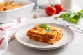 Piece of tasty hot lasagna served with a basil leaf on a gray plate. Italian cuisine, menu, recipe. Homemade meat lasagna. Close Royalty Free Stock Photo