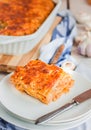 Piece of tasty hot lasagna served with on a white plate. Italian cuisine, menu, recipe. Homemade meat lasagna. Close up Royalty Free Stock Photo