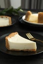 Piece of tasty vegan tofu cheesecake and fork on black wooden table, space for text Royalty Free Stock Photo