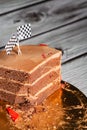 Piece of a tasty yummy chocolate cake with red racing stripes and flags