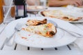 piece of thin crust pizza on white plate and white wooden desk in soft focus Royalty Free Stock Photo