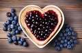 piece of toast bread inside of it cut heart filled with blueberry jam on plate and coffee cup on white wooden table top view Royalty Free Stock Photo