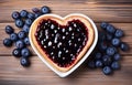 piece of toast bread inside of it cut heart filled with blueberry jam on plate and coffee cup on white wooden table top view Royalty Free Stock Photo