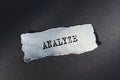 A piece of torn white paper with the word ANALYZE rests on a dark surface Royalty Free Stock Photo