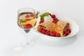 Piece of traditional apple strudel pie served with ice-cream, fresh mint, raspberry and glass of wine Royalty Free Stock Photo