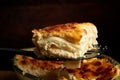 A piece of lasagna cooked in a glass pan over vintage wooden background, top view, close-up, selective focus Royalty Free Stock Photo