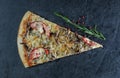 A piece of traditional pizza with a rosemary branch and berries on a gray stone background Royalty Free Stock Photo